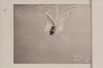 The "Esmeralda II" under the suspension bridge at Bright Angel Creek. The water patterns illustrate the drag which kept the speed so low