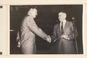 Rod Sanderson shakes hands with Interior Secretary Douglas McKay at the presentation of Gold Medal at Washington