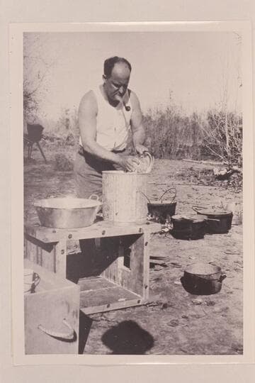 Val Woodbury washing dishes at Greenriver, Utah. Pathe-Bray party