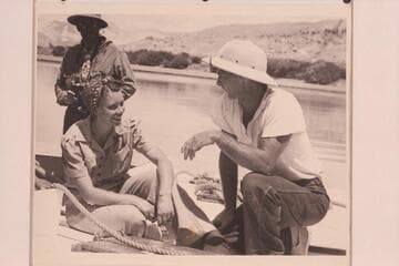 Doris Nevills and Norm Nevills posed during the run of 1940 from Green River, Wyoming, to Boulder City. Charley Larabee is in the background