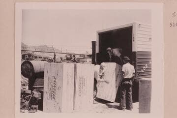 Evinrude Big Twin Outboards arrive at Boulder City. MacDonald is helping with the unloading at left as Jimmy Jordan watches the operation at the right