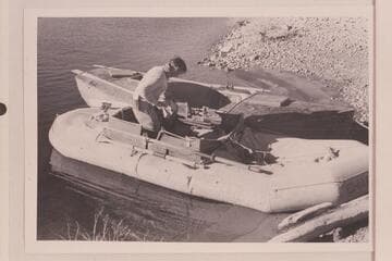 The rubber raft "Charlie" and the skiff "Julius F." at end of run from Wyoming to Lake Mead. Burg stands in the raft