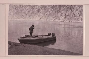 Rod Sanderson in the "Rattlesnake" used in the 1954, June Grand Canyon traverse.  The boats were of aluminum and 18 feet long with 6 feet of beam.  Power was from two 15HP Evinrude motors