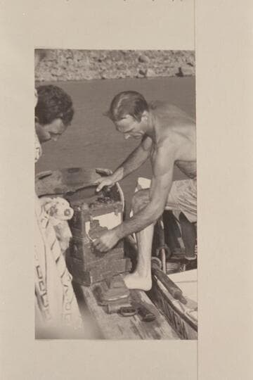 Nevills unloads the radio set recovered from the plateau below Point Sublime. It was dropped to the aviation men who had parachuted into the canyon in 1944