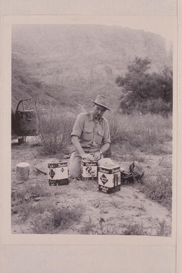 Bestor Robinson stowing food in slip-cover cans. Lees Ferry