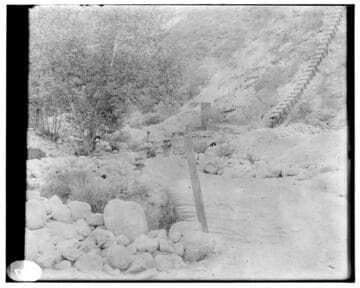 View of a flume in the mountains with a covered pipe in the background