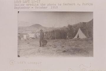 The Fort at Lees Ferry converted into a cook house and surrounded by tents for the first camp of the placer crew in the Spencer operations. Copy of print #12 in Waller collection. Waller credits the photo to Parkyn