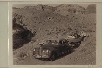 Hauling one of the Nevills sadirons to Lees Ferry. Pres Walker is hidden by Olsen in the boat. McConkie holds onto the side