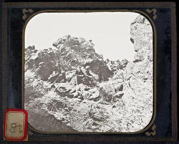 U.S. Army soldiers sitting among lava beds