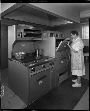 Lady chef checking food in commercial baking oven