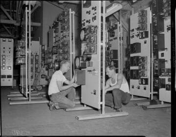 Men assembling panels at control center