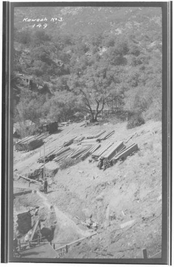 A construction crew building company cottages at Kaweah #3 Hydro Plant showing the building materials and a hill in the background