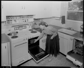 Woman placing food in oven