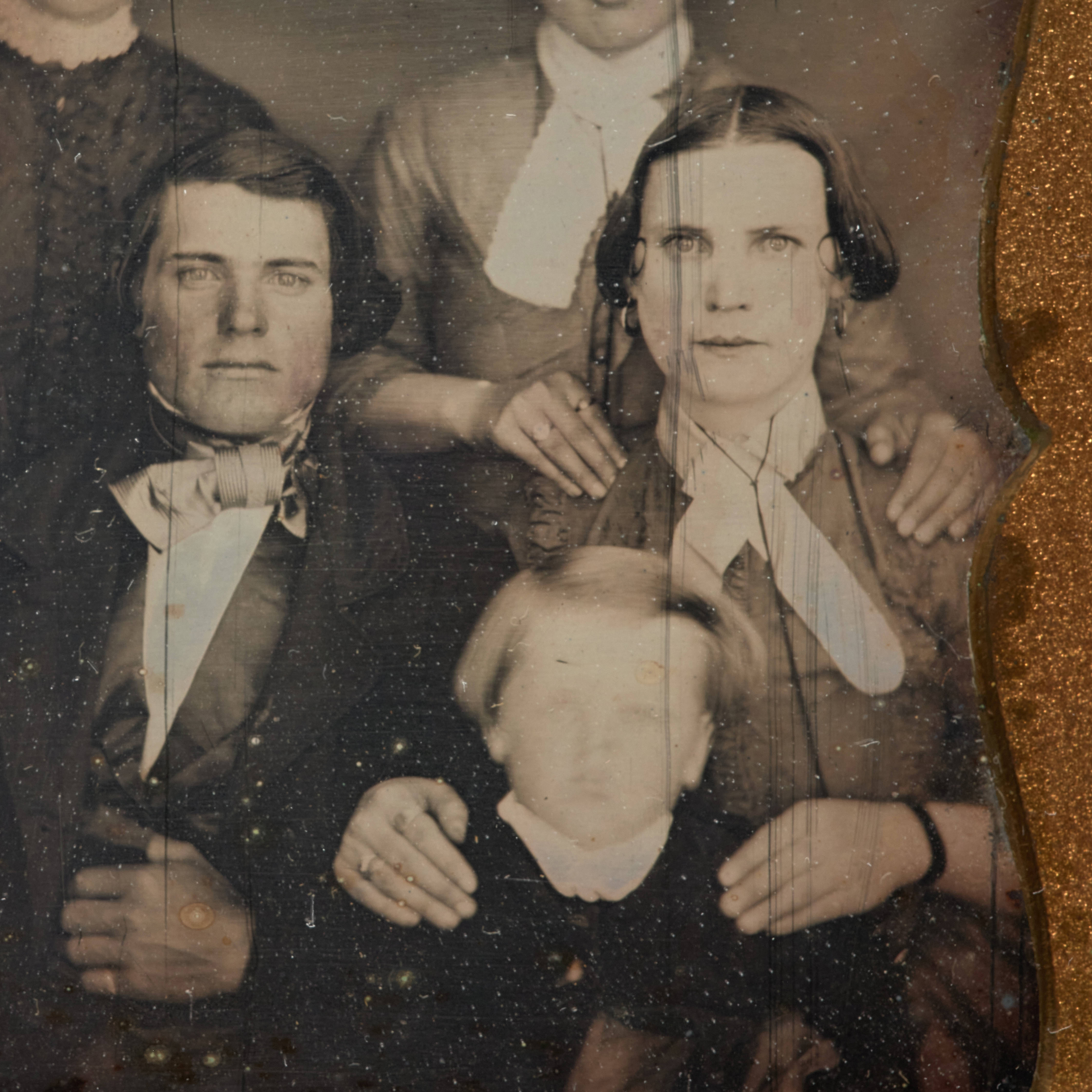 Close-up of a sepia-tone image of two parents and a child. 