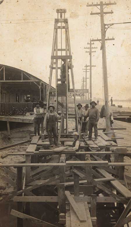 A group of workers on the beach in Santa Monica, ca. 1903. The man third from the right is Felix Puertas, the maternal grandfather of Ernest Marquez, who writes, “The location was between the Santa Monica Pier and the Ocean Park Pier, looking north toward Ocean Park. There was a big storm in 1903 that washed out the old wooden boardwalk. It appears the workers are driving piles into the sand to replace the old boardwalk with a cement one.” Photograph by H.F. Rile. 