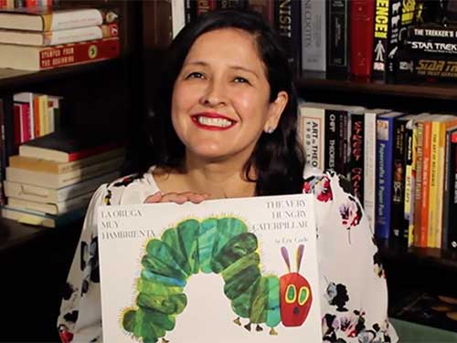 Staff member Cris with Very Hungry Caterpillar book