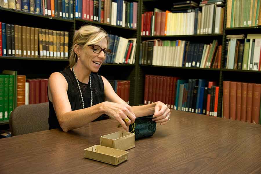 Andrea Denny-Brown, former Andrew W. Mellon Foundation Fellow at The Huntington, holds the silk purse that contains the arma Christi manuscript. Photograph by Kate Lain. Andrea Denny-Brown, former Andrew W. Mellon Foundation Fellow at The Huntington, holds the silk purse that contains the arma Christi manuscript. Photograph by Kate Lain.