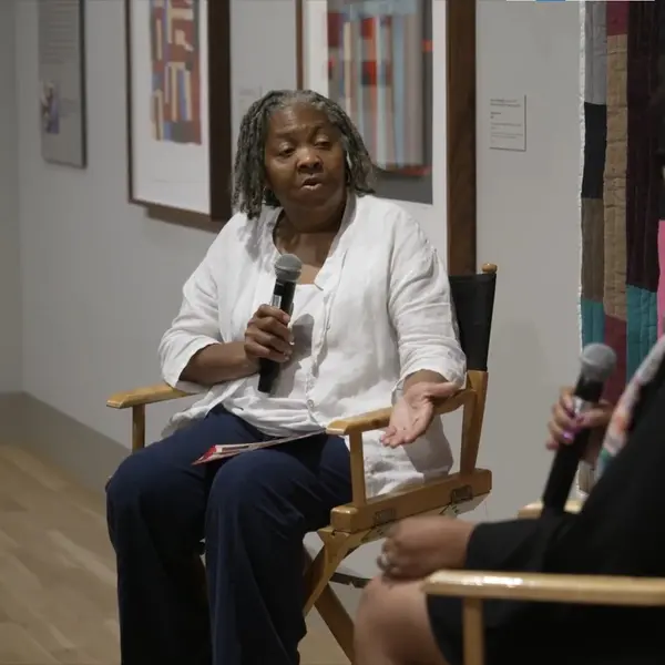 Curator Lauren Cross in conversation with Gee’s Bend Quiltmaker Louisiana Bendolph, in the gallery where the artist's work is displayed.