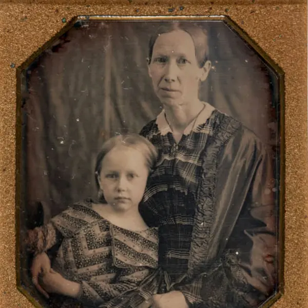 A framed black and white photo of a woman and young girl.