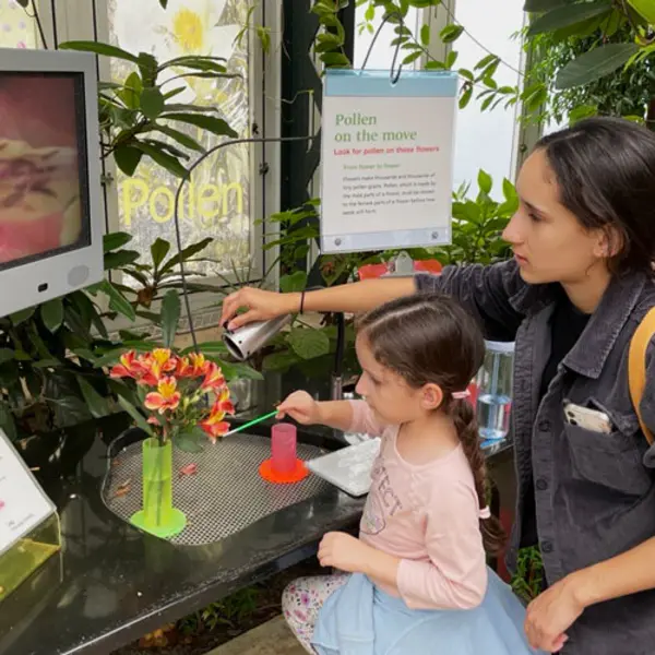 Two kids try an experiment with flower pollen in the Conservatory.