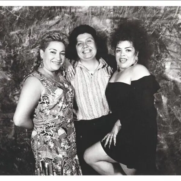Black and white photo of three people posing for the camera.