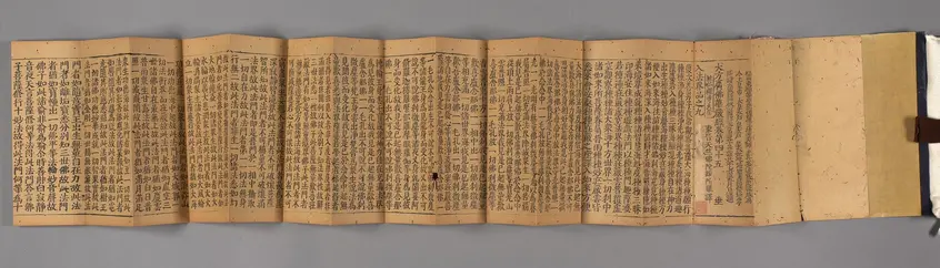 An 11th century printed Japanese document's pages are spread out.