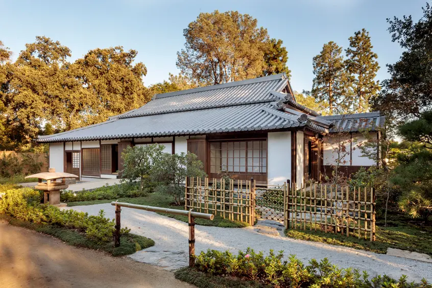Rear view of a traditional Japanese home, with a gravel path and private garden.