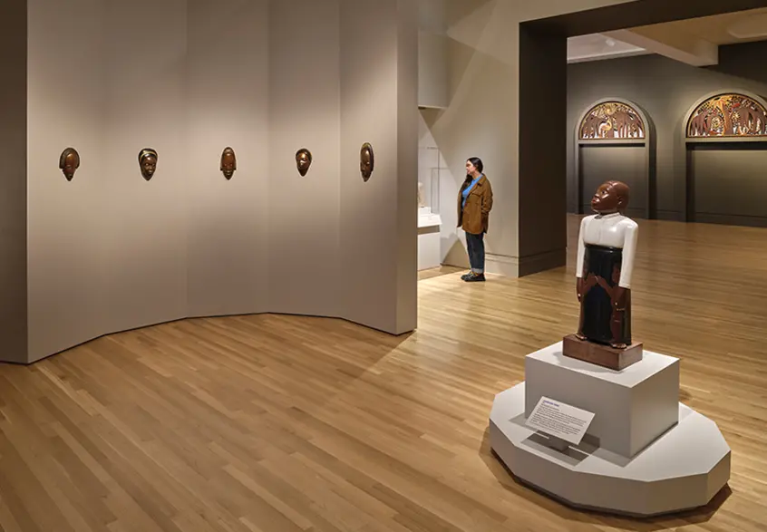 A person stands in a gallery looking at artwork.