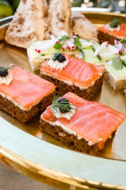 Closeup view of tea sandwiches, in the foreground is salmon with caviar.