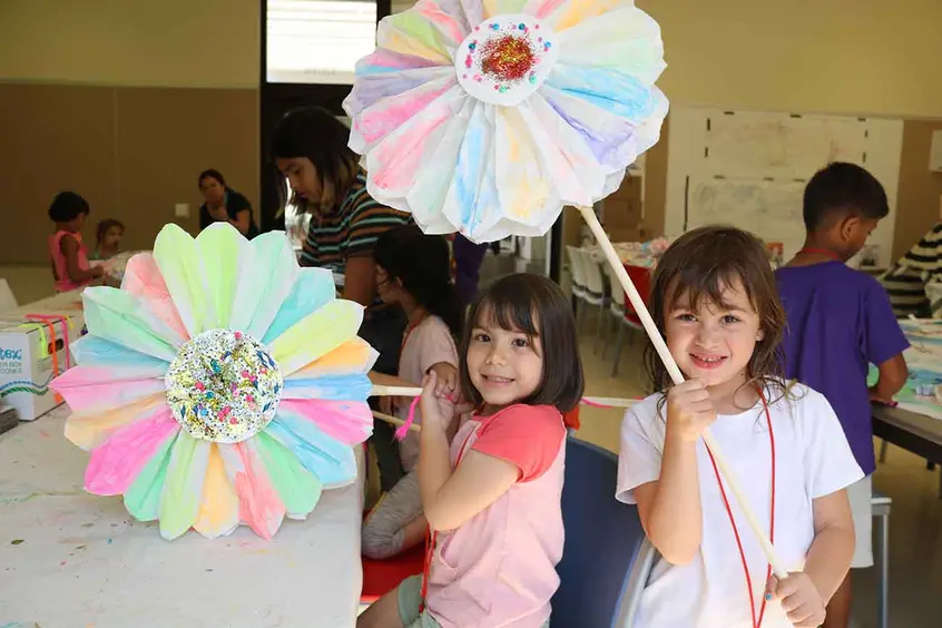 Explorers campers holding giant paper flowers