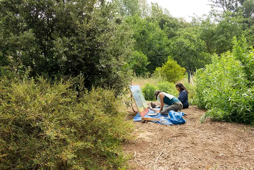 Olivia Chumacero sits alongside Sarita Dougherty as Dougherty works on a painting at The Huntington’s Ranch Garden.