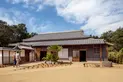 A traditional Japanese home with a gravel courtyard, on a sunny day.