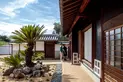 Visitors stand at the front entrance courtyard of a traditional Japanese home.