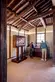 Visitors look at a display case inside a traditional Japanese home with an exposed wood-beam ceiling.