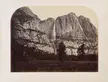 A black and white photograph of a great mountain range with a waterfall in the middle.