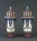 A matching pair of decorative pink and white ceramic vases resembling an ornate castle