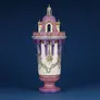 Decorative pink and white ceramic vase resembling an ornate castle