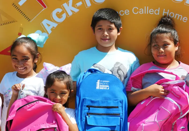 young school kids smiling with backpacks