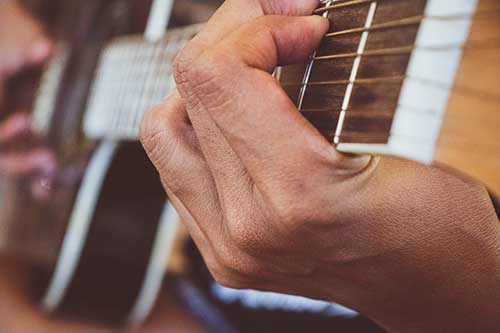 Person playing guitar. Photo by Alaine Johnson