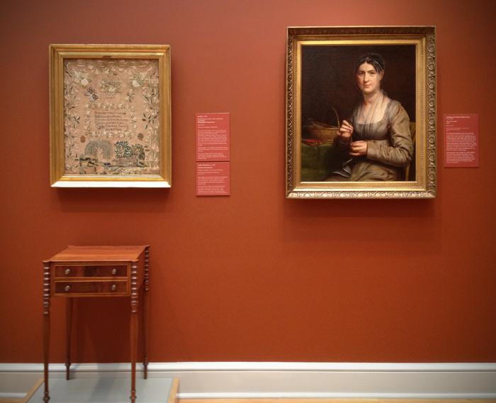 Elizabeth Justice's sampler on display with a portrait of Tacy Shoemaker, 1818.