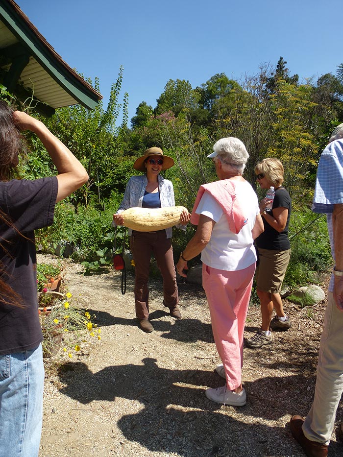 Ranch coordinator Kyra Saegusa shows off a Georgia candy roaster squash weighing 21 pounds. Fruits and vegetables grown on the Ranch are donated to the local Friends in Deed food bank.