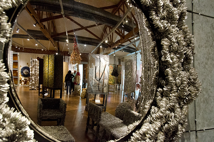 A view of the exhibition's main room, as seen through a Graham-made, soda can tab–festooned looking glass.