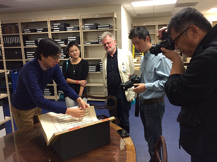 Huntington archivist Li Wei Yang (left) and Duncan Campbell show the new discovery to a group of journalists.