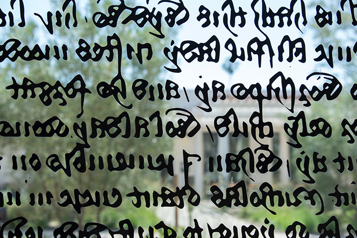 Chaucerian calligraphy lends its intricate forms to the front windows of the Mapel Orientation Gallery.