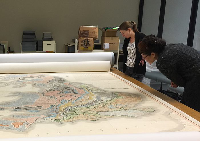 The Claremont Colleges Library’s copy of William Smith’s map, A Delineation of the Strata of England and Wales, published in 1815, at the Honnold-Mudd Library in Claremont. This map will be on display in a classroom adjacent to Rothenberg Hall for half an hour before and one hour after Simon Winchester's talk about William Smith on Dec. 8. Annie Wilker (left), senior paper conservator at The Huntington, and Lauren Tawa, exhibits manager at The Huntington, take a close look at the map. Photo by Holly Moore.