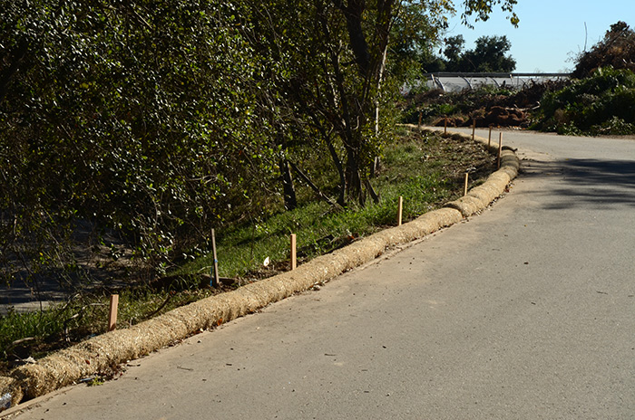 Rolls of straw wattle will help control erosion and debris flow on slopes, keeping the drainage system clear and running efficiently. Photo by Lisa Blackburn.