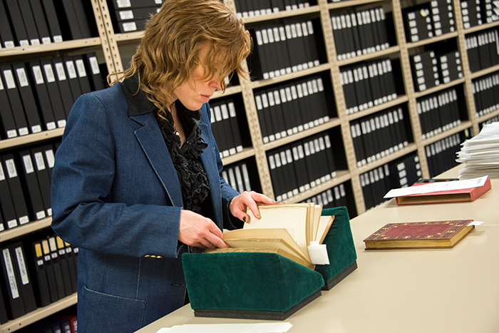 kerrie welsh (now Kiki Loveday) looks through an 1888 copy of Alphonse Daudet's Sappho: Parisian manners. Photo by Kate Lain.