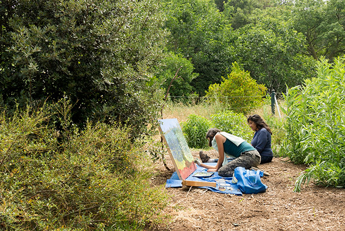 Olivia Chumacero sits alongside Sarita Dougherty as Dougherty works on a painting at The Huntington’s Ranch Garden. Photo by Kate Lain.