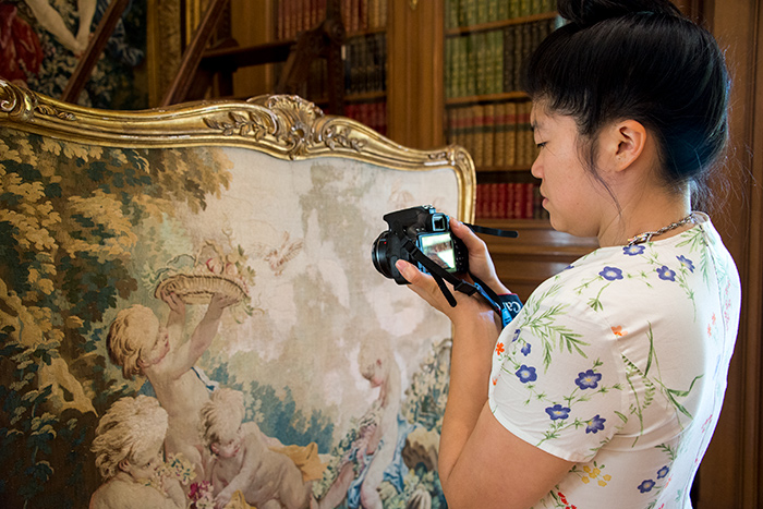 Soyoung Shin photographs an 18th-century tapestry-covered fire screen in the Huntington Art Gallery as part of her research. Photo by Kate Lain.