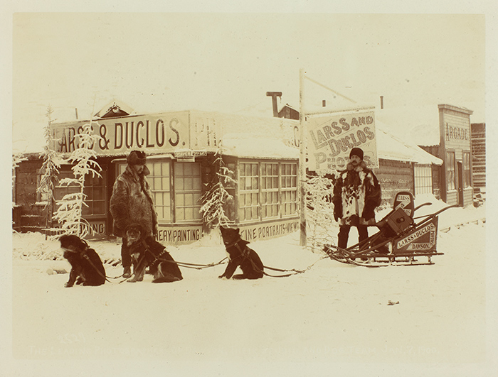 Joseph E.N. Duclos (1863–1917) and Per Edward Larss (1863–1941) in front of their Dawson City photography studio, with dog team and Larss & Duclos sled, around 1898. Unidentified photographer. The Huntington Library, Art Collections, and Botanical Gardens.